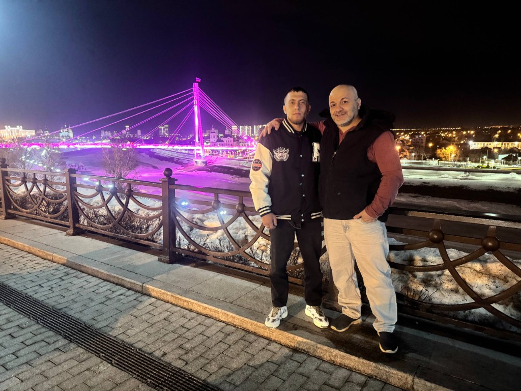 Вениус и Гика, март 2026, на набережной ночью, на фоне подсвеченный мост